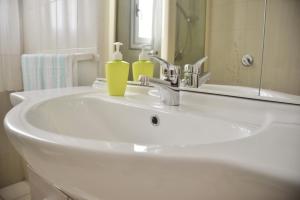 兰佩杜萨Case Vacanze Porto Vecchio的白色浴室水槽和2个肥皂瓶