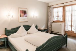 索尔登奥特凯撒酒店的一间卧室配有带白色枕头的绿色床