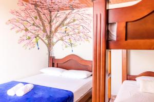 萨兰托Hospedaje La Masia Salento的一间卧室设有两张双层床和一棵树壁画