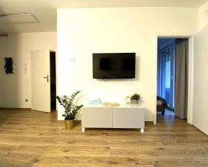 波兰尼卡-兹德鲁伊Apartamenty Polanica Zdrój的客厅配有白色桌子和墙上的电视