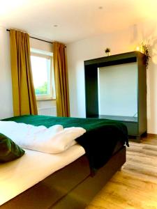 汉诺威Airport & Messe Apartments的一间卧室设有一张带窗户的大型绿色床