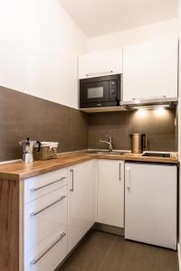 贝谢诺瓦Apartmán Dagmar的厨房配有白色橱柜和微波炉