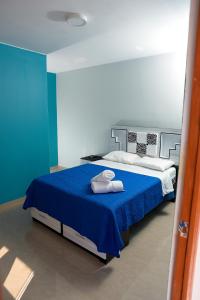 伊察Hostel Boulevard的一间卧室配有蓝色的床和毛巾