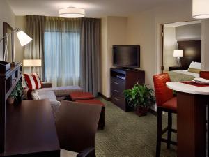 WarrendaleStaybridge Suites - Pittsburgh-Cranberry Township, an IHG Hotel的酒店套房设有一间带一张床和电视的客厅