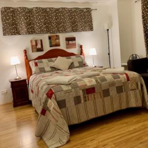 珀斯Ascot Comfort的一间卧室配有一张带毯子和两盏灯的床。