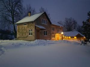 科索夫Fazenda Kosiv的夜晚有雪覆盖的房子