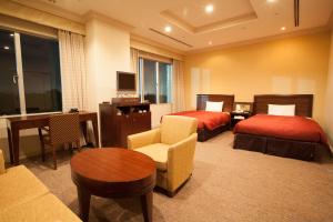 成田成田捷得威大飯店的酒店客房设有两张床和一张桌子。