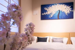 东京Sakura Stay Otorii的一间卧室设有两张床,墙上挂着一幅画
