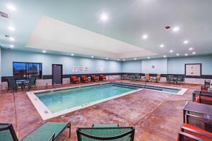 LordHoliday Inn Express & Suites Perryton, an IHG Hotel的大型客房内的游泳池,配有桌椅