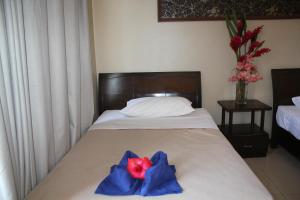 维拉港City Lodge的一间卧室,床上有红花