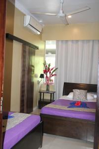 维拉港City Lodge的一间卧室设有两张带紫色床单的床和窗户。
