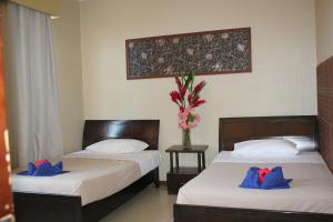 维拉港City Lodge的两张位于酒店客房的床,配有蓝色枕头