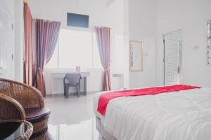 占碑市RedDoorz Syariah near Arafah Hospital Jambi的一间卧室配有一张床、一张桌子和一个窗户。