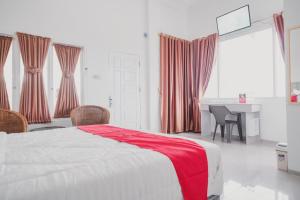 占碑市RedDoorz Syariah near Arafah Hospital Jambi的一间卧室配有一张床铺,床上铺有红色毯子