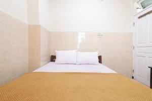 SukodonoHotel Omah Ampel Syariah的一张带白色床单和枕头的床
