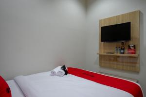 三宝垄RedDoorz @ Jalan Kartini Semarang的一间设有一张红白毯子的床的房间