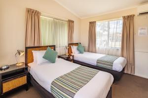 Emu Plains比格斯尼皮恩河假日公园的酒店客房设有两张床和窗户。