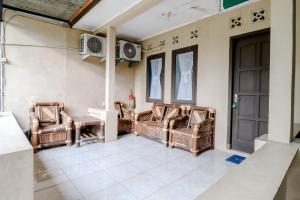 SalakanHomestay Damandiri Prambanan Syariah的客厅配有3把椅子和风扇