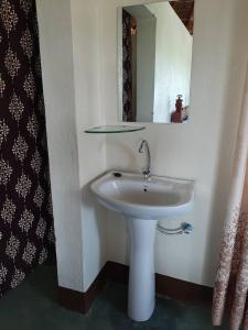 Pakwach EastTangi Safari Lodge的浴室设有白色水槽和镜子