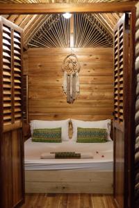 圣维森特Palayan Paradise Huts的木墙客房的一张床位