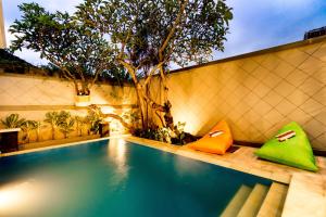 塞米亚克Villa Chandra - 3 Bedroom Villa with Private Pool的一座游泳池,旁边是绿橙色枕头