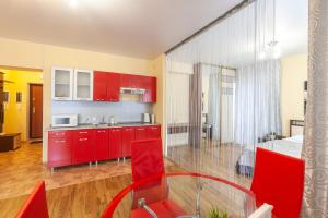 秋明Апарт-отель 7 этажей Тюмень Центр的厨房配有红色橱柜和红色的桌椅