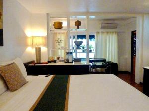 芭东海滩百佛生活公寓的一间卧室设有一张床和一间客厅。