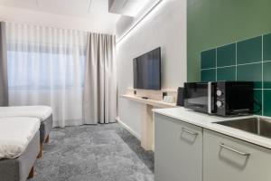 瓦萨GreenStar Hotel Vaasa的酒店客房设有床、水槽和电视