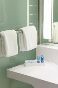 突尼斯突尼斯宜必思酒店的浴室配有盥洗盆、镜子和毛巾