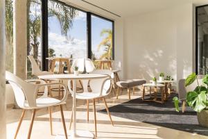 帕特纳AZZ Valencia Táctica Hotel的一间设有白色椅子和桌子的用餐室以及窗户。