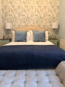 波特拉什The Carrick的卧室内的一张带蓝色床单和枕头的床