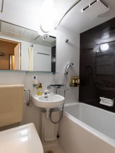福冈天神艾特瓦斯酒店的浴室配有盥洗盆和浴缸。