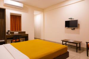 浦那Hotel Dreamland的酒店客房设有一张床、一张书桌和一台电视机。
