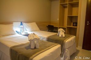 累西腓Hotel Enseada Aeroporto的在酒店房间设有两张床,里面装满了动物