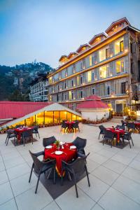 西姆拉Snow Valley Resorts Shimla的一座配有桌椅的庭院和一座建筑