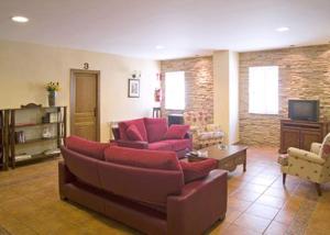 Cirat拉彼德拉德尔美迪蒂亚酒店的客厅配有红色沙发和电视