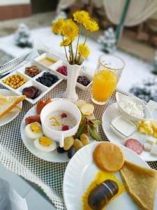 塔什干Home Boutique Hotel的一张桌子,上面放着一盘早餐食品和一杯橙汁