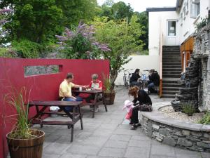 基拉尼Killarney Railway Hostel的一群坐在花园里桌子上的人