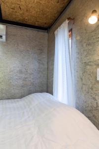 Ban Huai SalokThe Nanda Resort的卧室配有白色的床和窗户。