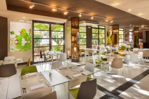 洛斯克里斯蒂亚诺斯Aguamar Apartamentos, Los Cristianos Downtown的餐厅设有白色的桌椅和窗户。