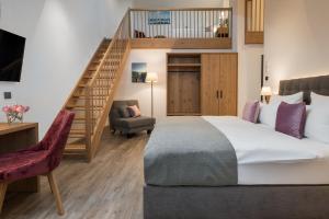 慕尼黑奥贝梅耶酒店的一间带大床和楼梯的卧室
