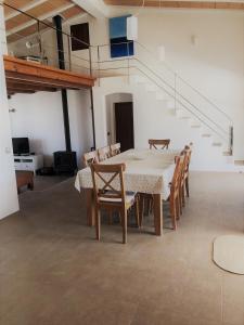 拉莫拉Casa S'Olibassa的一间带桌椅和楼梯的用餐室