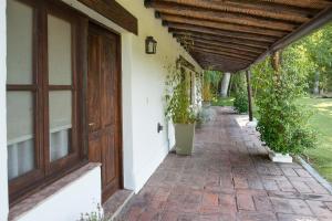 Colonia Las Rosas泊戴斯巴耶 - 合众精品酒店的门廊,有木门和盆栽植物