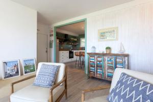 加瓦Gavamar Castelldefels Beachfront Apartment- Direct access to the beach的一间带两把椅子的客厅和一间厨房