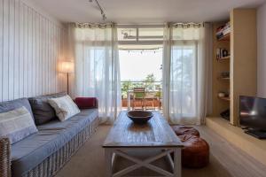 加瓦Gavamar Castelldefels Beachfront Apartment- Direct access to the beach的客厅配有沙发和桌子