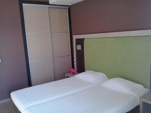沃洛斯凯普赛狄酒店的一间卧室配有两张白色的床和大镜子