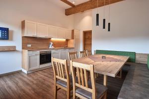 弗拉绍Appartment Ransburggut的厨房以及带木桌和椅子的用餐室。
