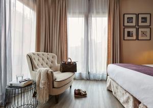 巴塞罗那巴塞罗纳卡泰多拉尔酒店的酒店客房带椅子和床