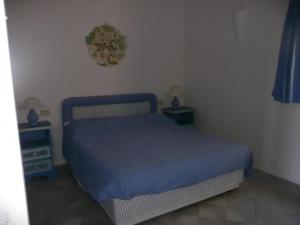 巴哈撒丁岛Cormorani Alti的一间卧室配有蓝色的床和2个床头柜