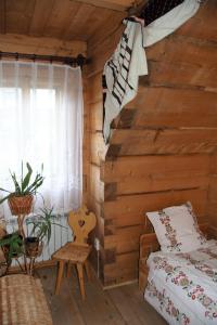 考斯赛力克Pokoje Gościnne Kościelisko AZ Somatic的小木屋内的卧室,配有床和窗户